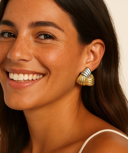 Modella sorridente che indossa orecchini a triangolo bicolore oro e argento, look vintage elegante - Suntime Moda