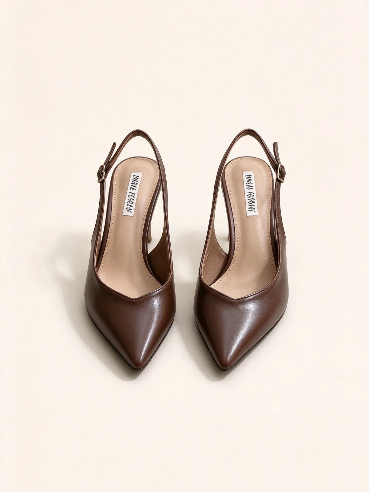 Un paio di scarpe décolleté slingback marrone scuro a punta in ecopelle con tacco alto, viste dall'alto su sfondo chiaro - SUNTIMEMODA