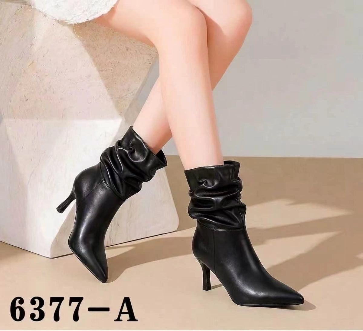 Modella che indossa stivaletti neri a punta con gambale arricciato (modello 6377-A) abbinati a un abito per un look femminile - SUNTIMEMODA