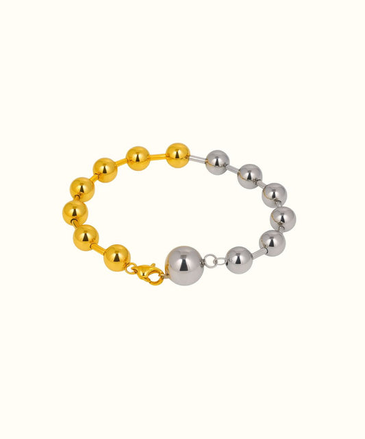 Bracciale rigido a sfere modello Bicolor con finitura metà oro e metà argento su sfondo bianco - Suntime Moda