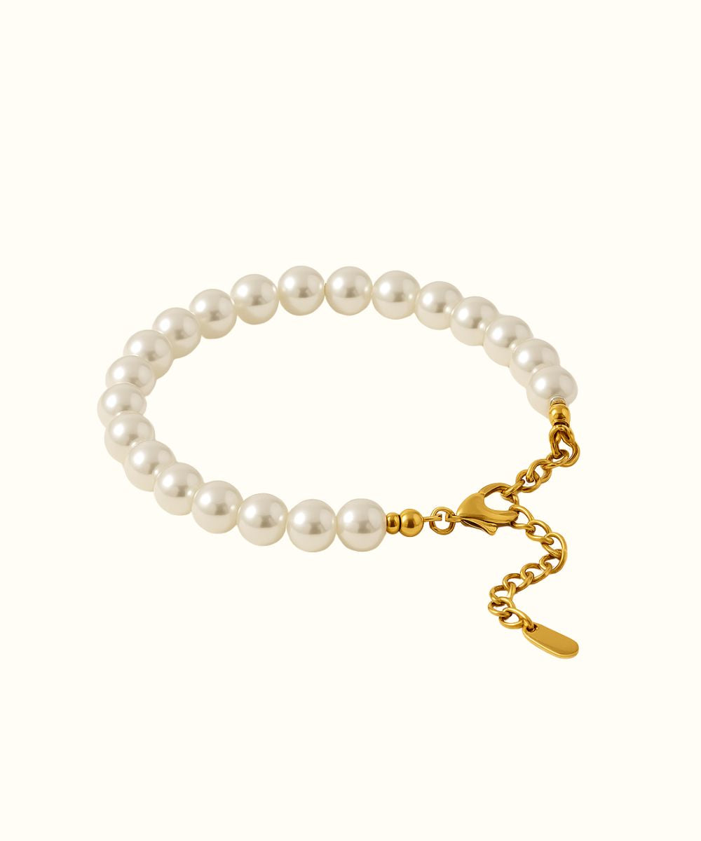 Bracciale di perle rotonde con catenella regolabile e chiusura a moschettone in oro su sfondo bianco - Suntime Moda