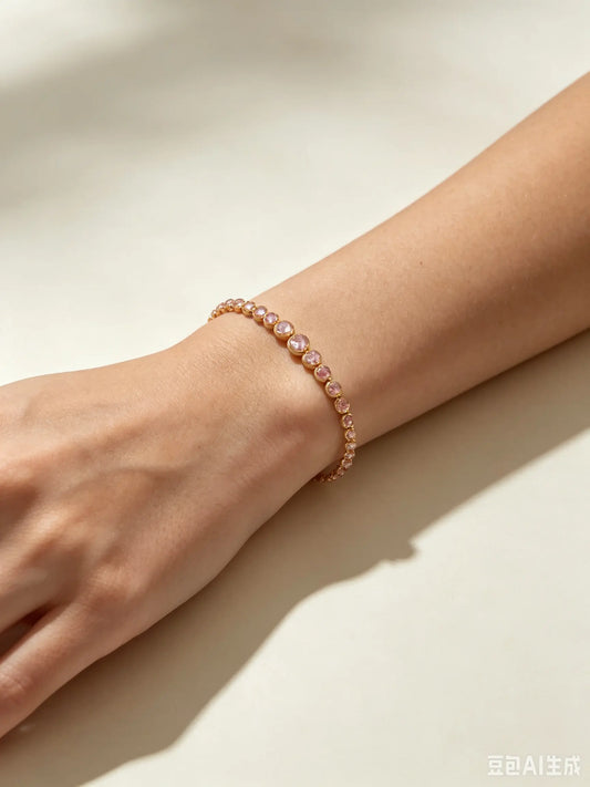 Donna che indossa un delicato bracciale dorato con cristalli rosa e rosa chiaro alternati sul polso - SUNTIMEMODA