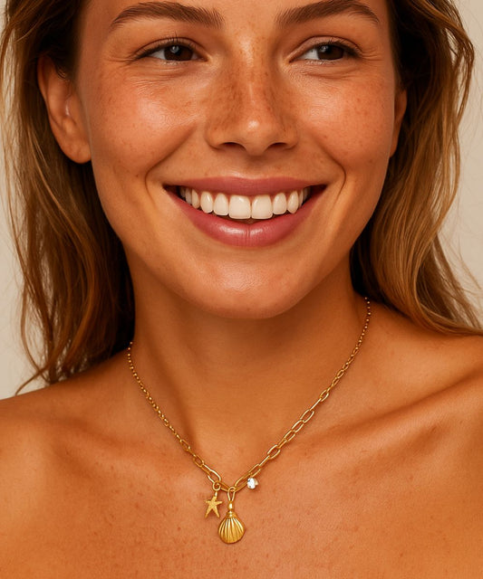 Modella sorridente che indossa la collana Ibiza con pendenti a tema mare, look estivo e luminoso - Suntime Moda