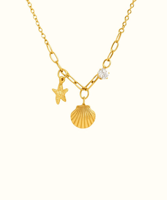 Collana Ibiza in oro con catena a maglie larghe e pendenti a forma di stella marina e conchiglia su sfondo bianco - Suntime Moda