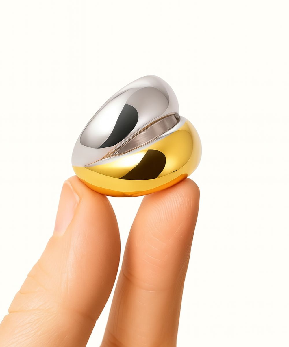 Dettaglio ear cuff bicolor tenuto tra le dita per mostrare la finitura lucida oro e argento e la forma spessa - Suntime Moda