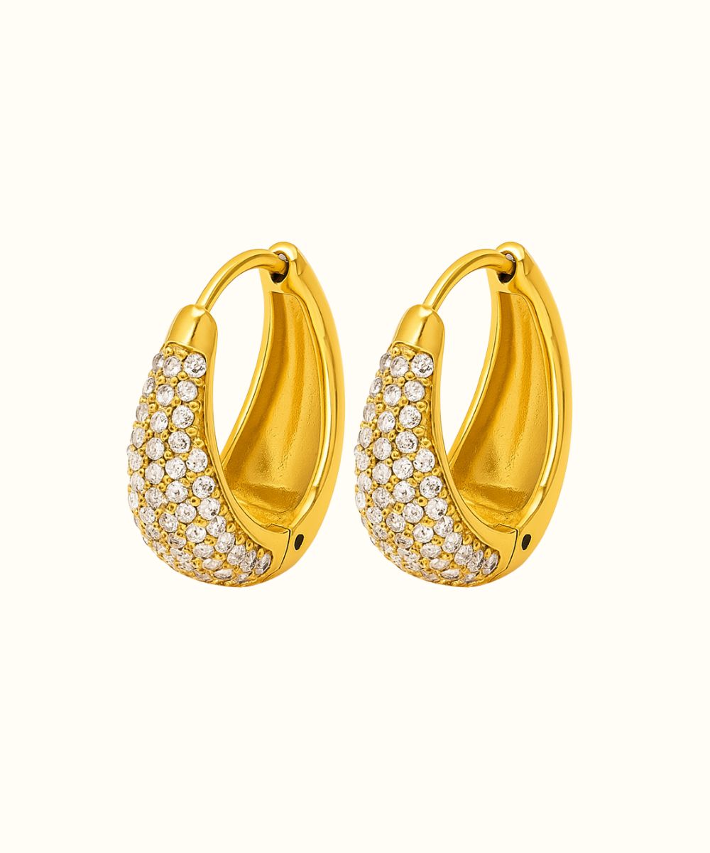 Coppia di orecchini a cerchietto ovali modello Lux in oro con pavé di zirconi luminosi su sfondo bianco - Suntime Moda
