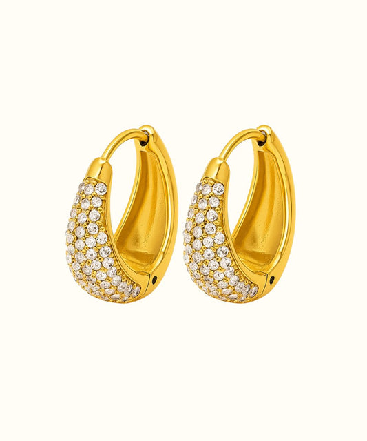 Coppia di orecchini a cerchietto ovali modello Lux in oro con pavé di zirconi luminosi su sfondo bianco - Suntime Moda