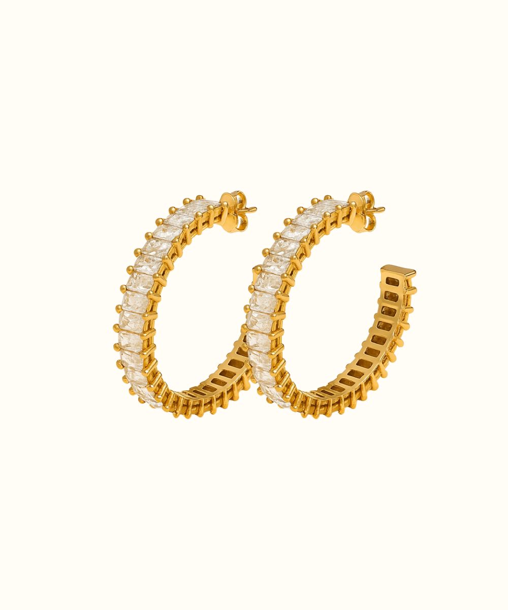 Dettaglio modella che indossa orecchini a cerchio grandi in acciaio color oro con fila di zirconi rettangolari - Suntime Moda