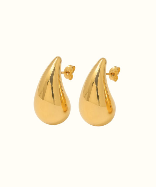 Coppia di orecchini pendenti modello Goccia in oro su sfondo bianco per un look minimal chic - Suntime Moda