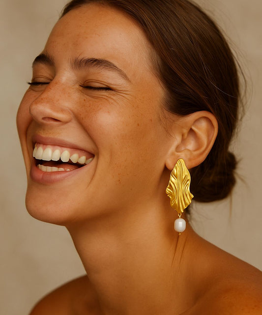 Modella sorridente che indossa gli orecchini Inside con perla naturale per un look radioso ed elegante - Suntime Moda