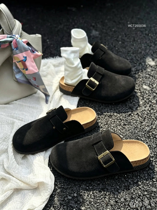 Un paio di sabot da donna JOMIX neri effetto camoscio indossati con calzini bianchi in un look casual da strada - SUNTIMEMODA