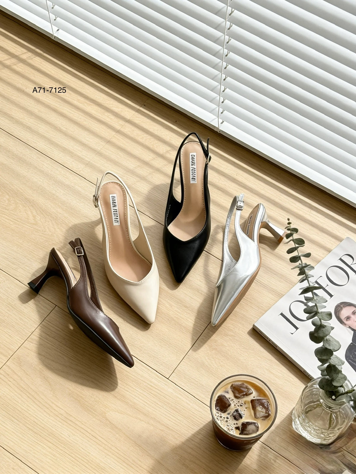 Catalogo delle décolleté slingback articolo A71-7125, esposte su un pavimento in legno con rivista e caffè, nei colori marrone, beige, nero e argento - SUNTIMEMODA
