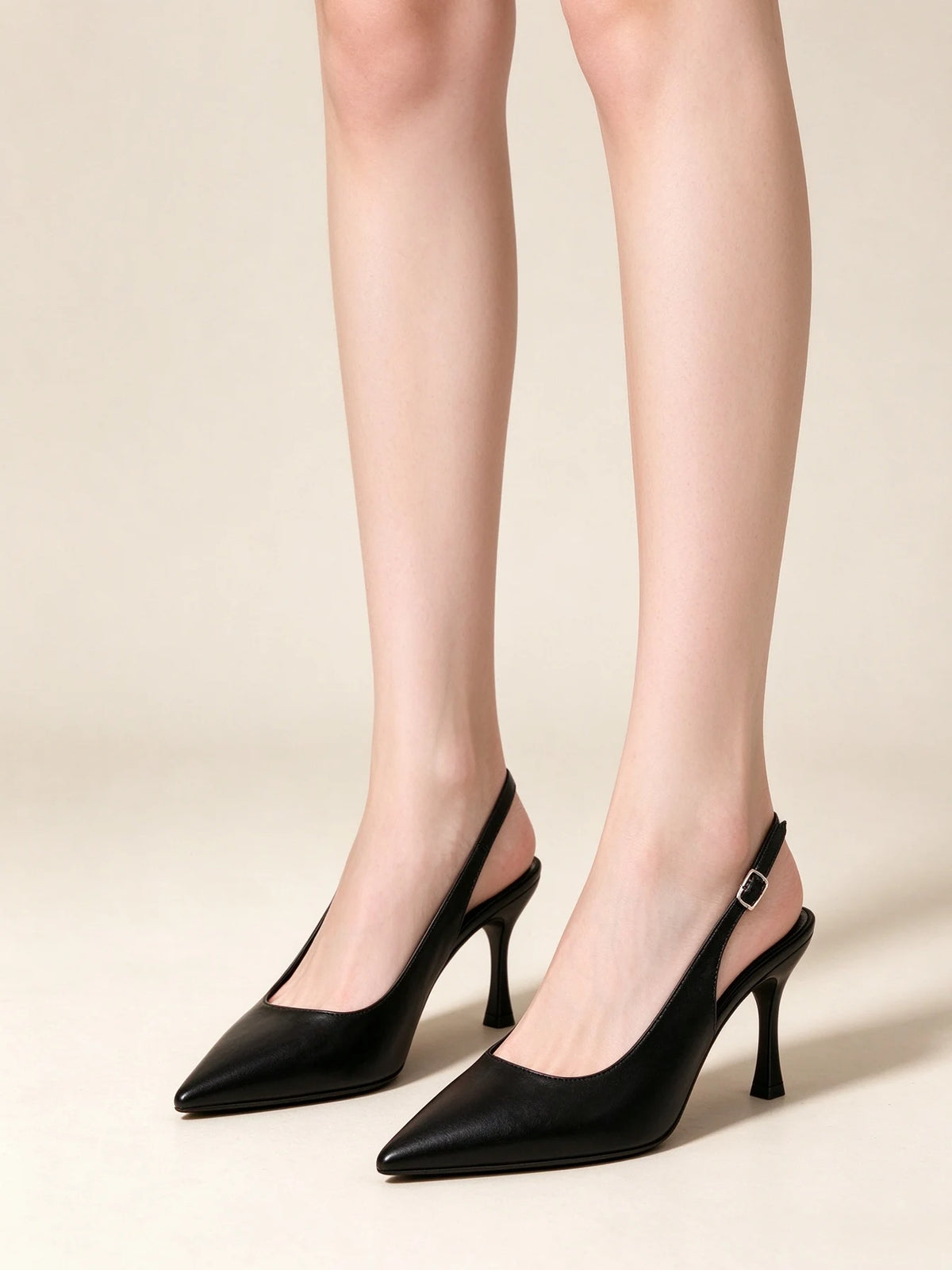 Modella che indossa eleganti scarpe slingback nere a punta con tacco a spillo e cinturino posteriore, vista frontale - SUNTIMEMODA