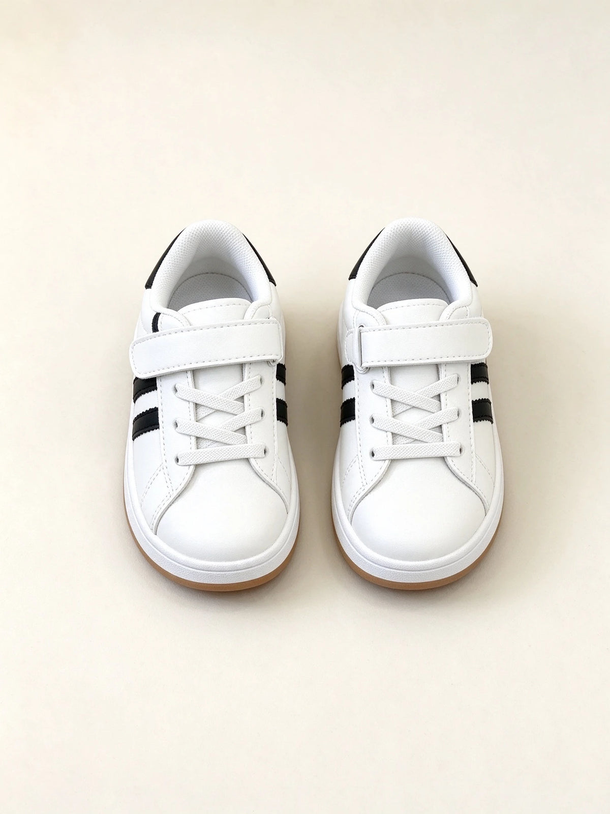 Sneakers bianche per bambini con strisce nere e chiusura a strappo, vista frontale e dall'alto su sfondo neutro. - SUNTIMEMODA